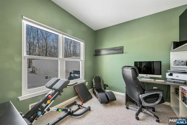 a view of a workspace with furniture and a window