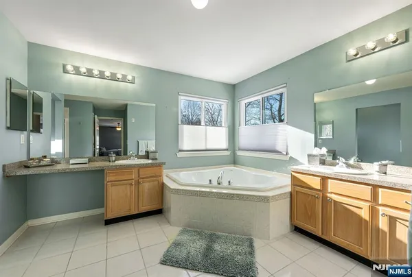 a bathroom with a tub a sink and mirror