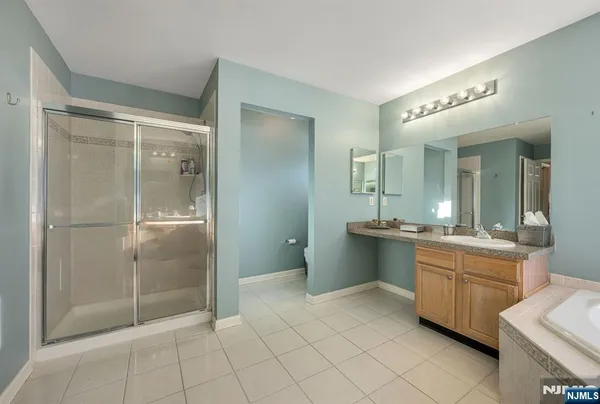 a bathroom with a mirror a sink and a glass door shower