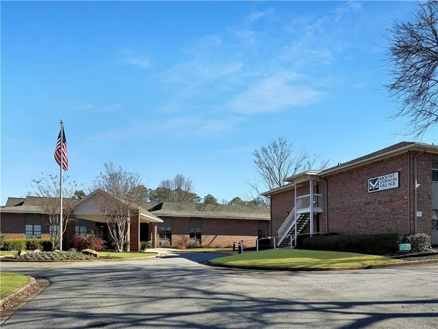 a front view of a building with lots of trees