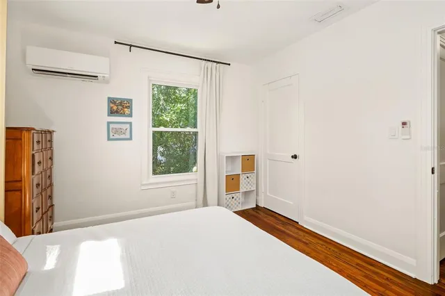 a bedroom with a bed and wooden floor