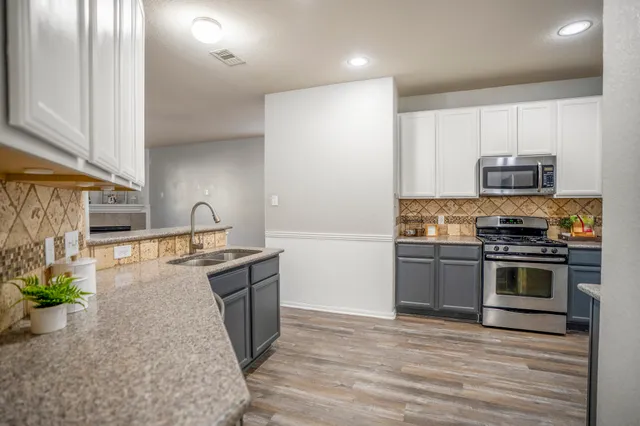 a kitchen with stainless steel appliances granite countertop a stove a sink and a refrigerator