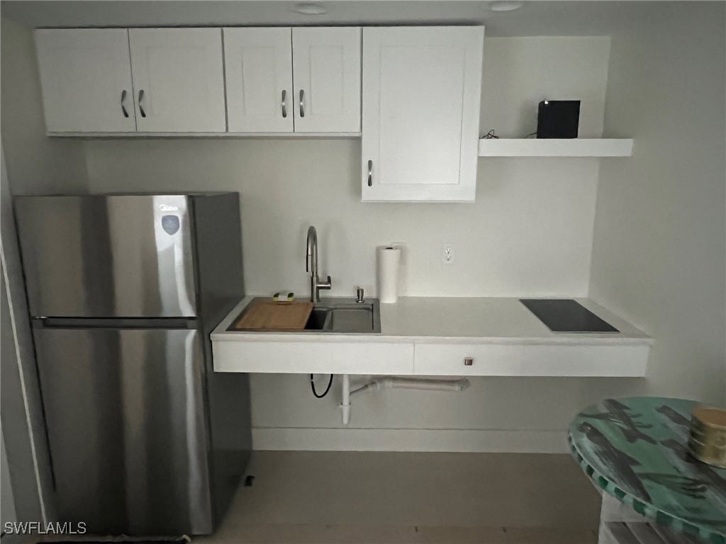 11458 May Street, Unit 1 Matlacha, FL 33993 - Photo 4 of 18 a kitchen with a refrigerator and cabinets