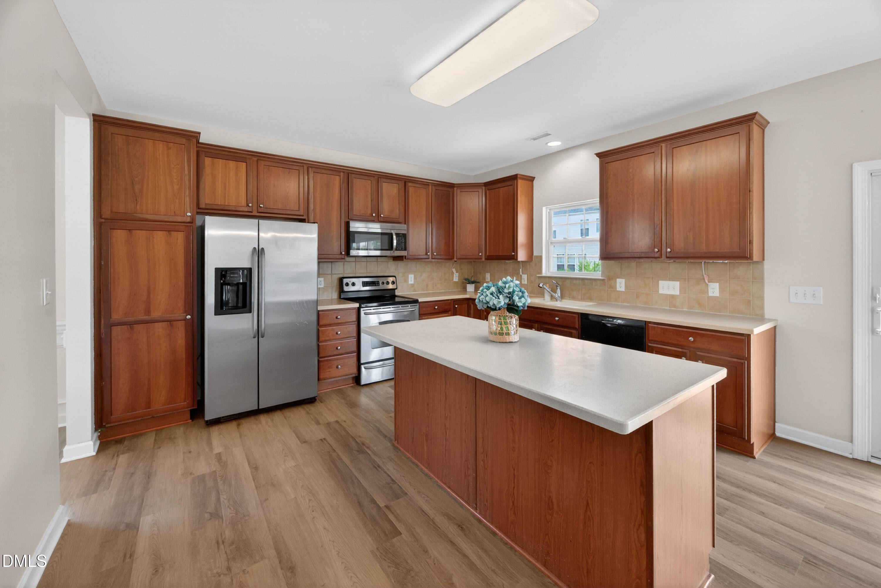 5304 Stone Station Drive Raleigh, NC 27616 - Photo 8 of 34 a kitchen with stainless steel appliances granite countertop a refrigerator a sink a stove a microwave and wooden floors
