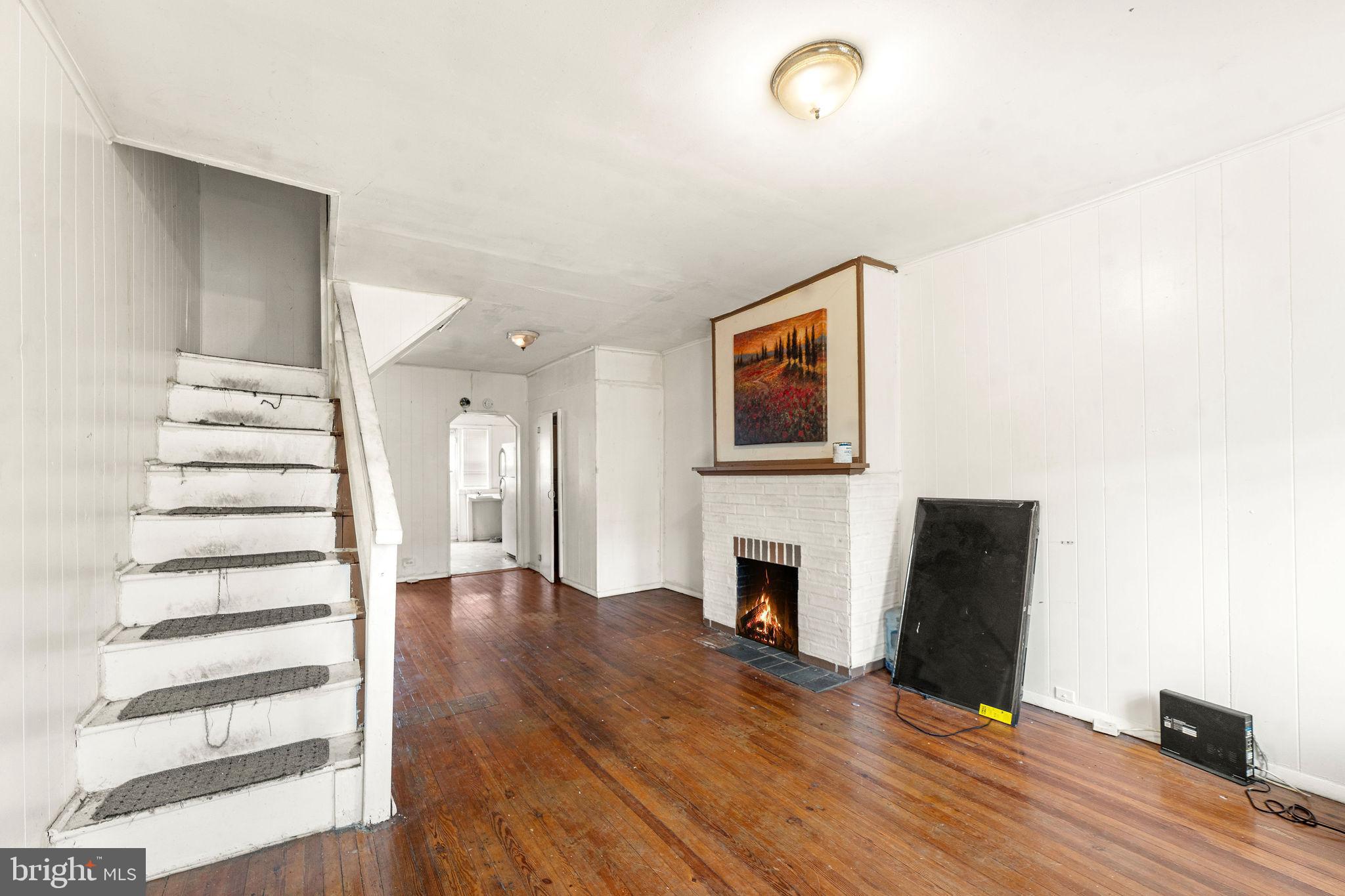 1263 South Merrimac Road Camden, NJ 08104 - Photo 2 of 21 a view of a livingroom with wooden floor and staircase