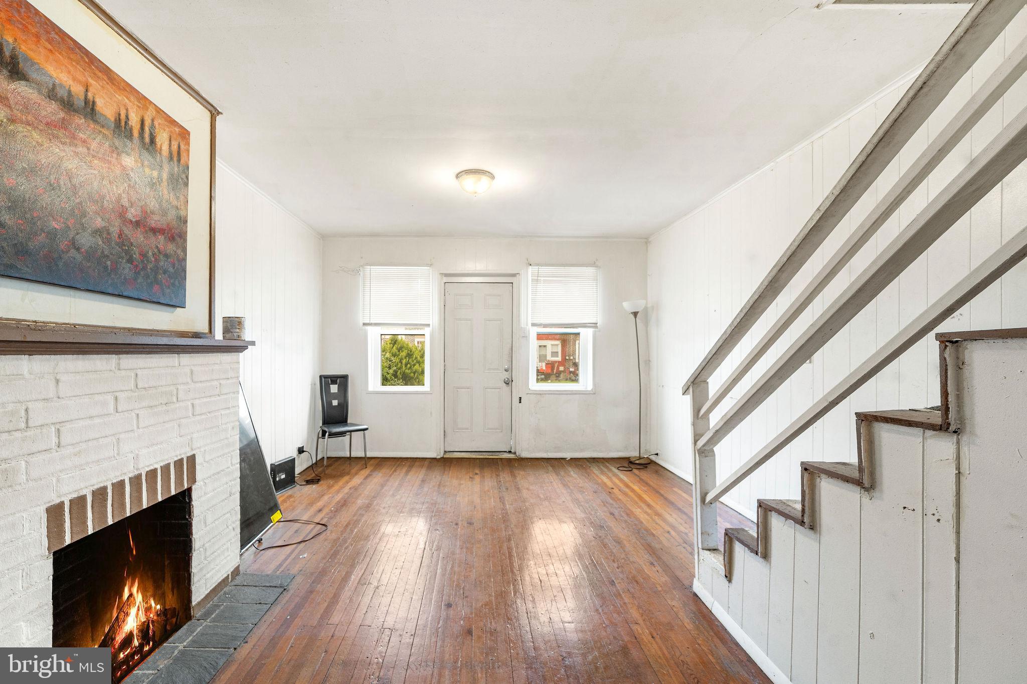 1263 South Merrimac Road Camden, NJ 08104 - Photo 3 of 21 a view of an empty room with wooden floor fireplace and a window