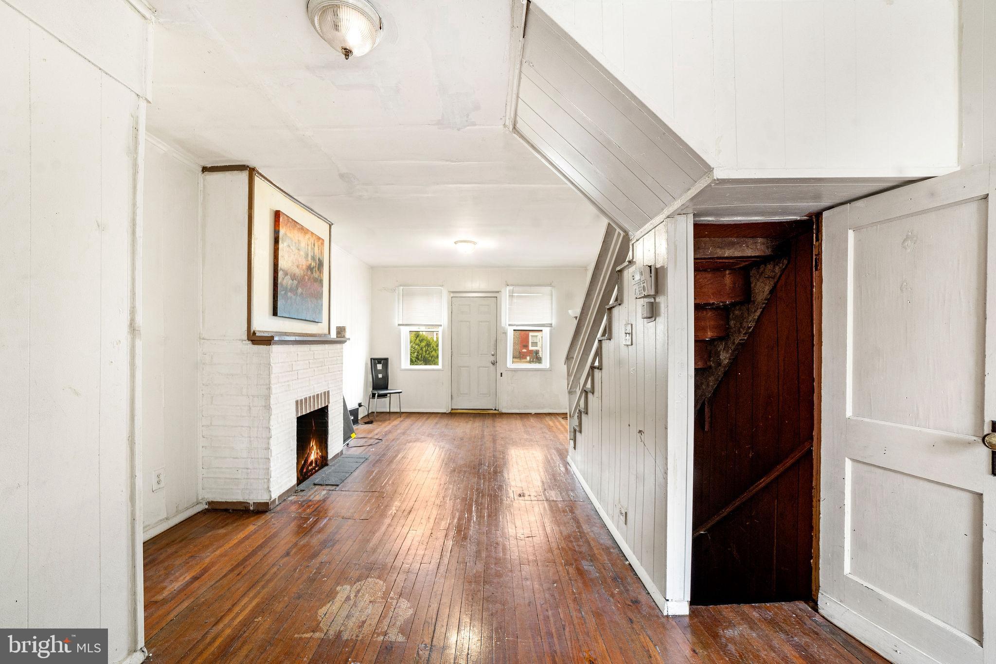 1263 South Merrimac Road Camden, NJ 08104 - Photo 7 of 21 a view of a hallway with wooden floor and a fireplace