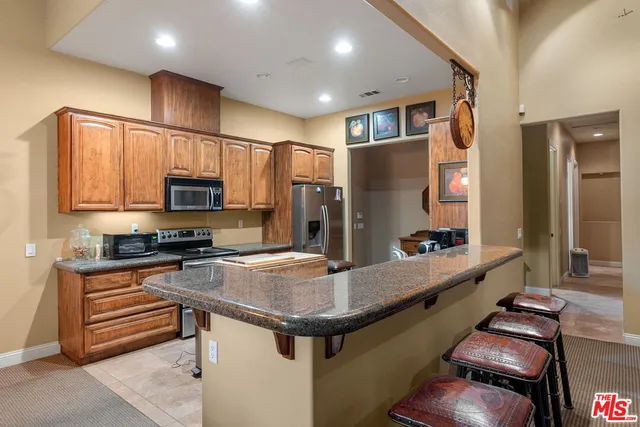 a kitchen with stainless steel appliances granite countertop a sink a stove and a refrigerator