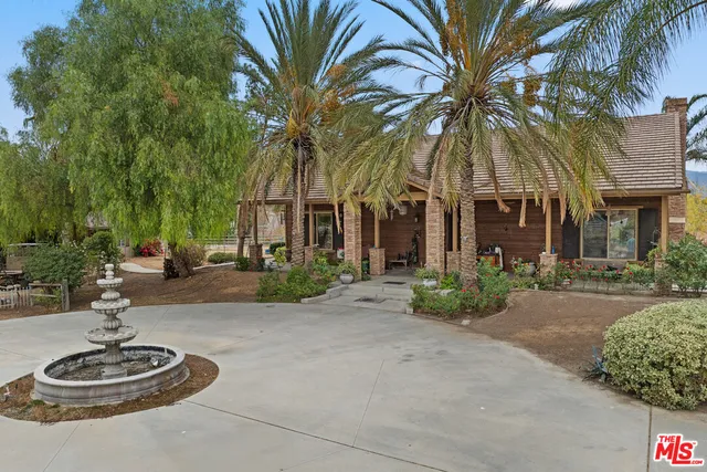 a backyard of a house with fountain table and chairs