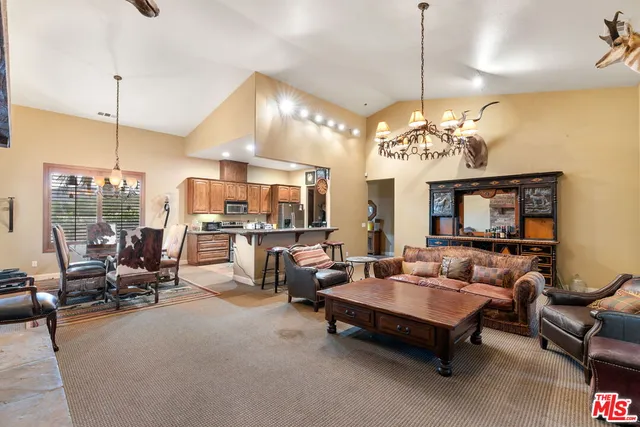 a living room with patio furniture and a chandelier