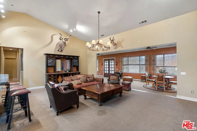 a living room with furniture a chandelier and a dining table