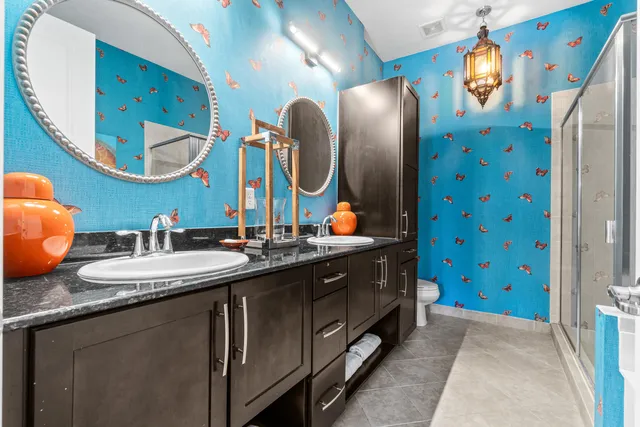 a bathroom with double vanity sinks and a mirror