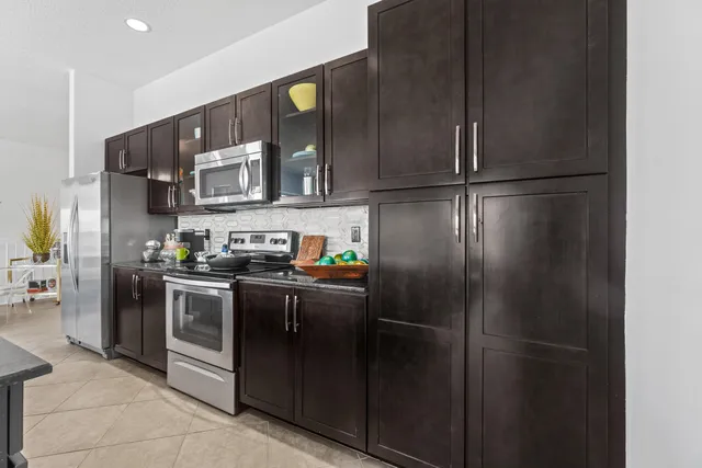 a kitchen with stainless steel appliances granite countertop a refrigerator and a sink