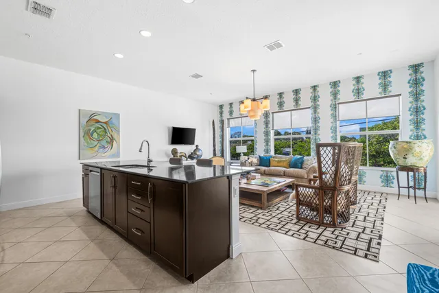 a view of kitchen with stainless steel appliances granite countertop a sink and a living room