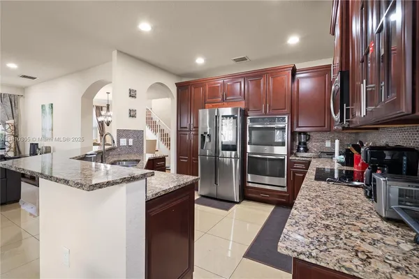 a kitchen with kitchen island granite countertop a stove and a sink