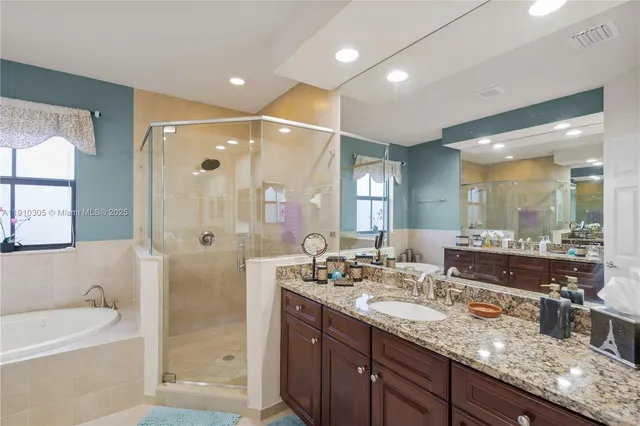 a bathroom with a double vanity sink toilet mirror and shower
