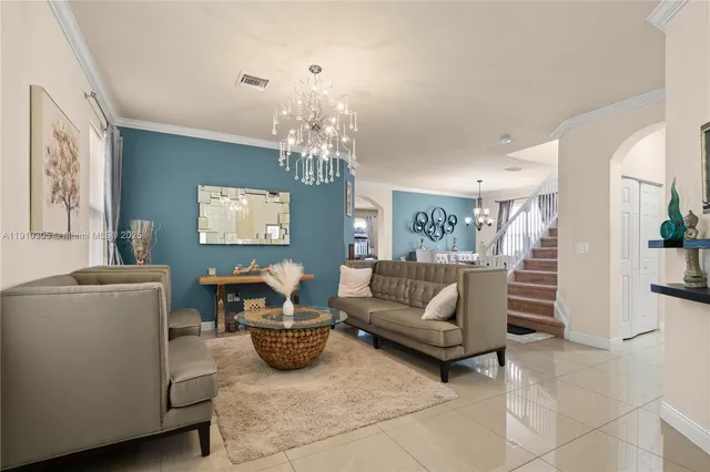 a living room with furniture and a chandelier