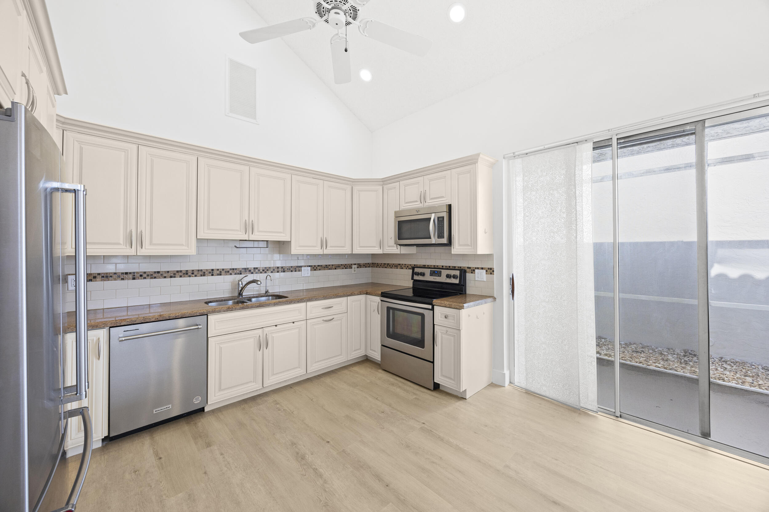 17192 Newport Club Drive Boca Raton, FL 33496 - Photo 12 of 72 a kitchen with white cabinets and white appliances