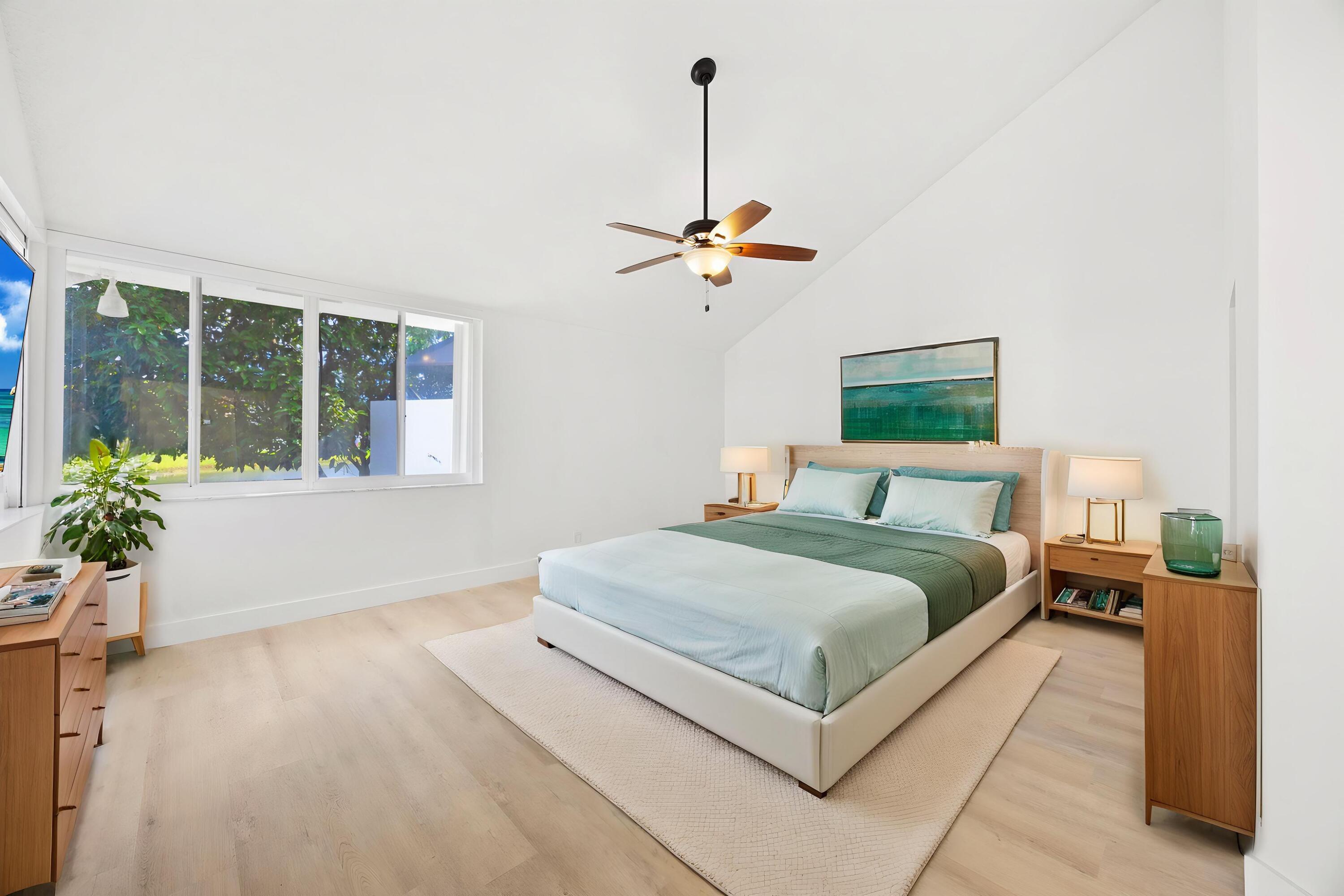 17192 Newport Club Drive Boca Raton, FL 33496 - Photo 20 of 72 a bedroom with a large bed chandelier and a window