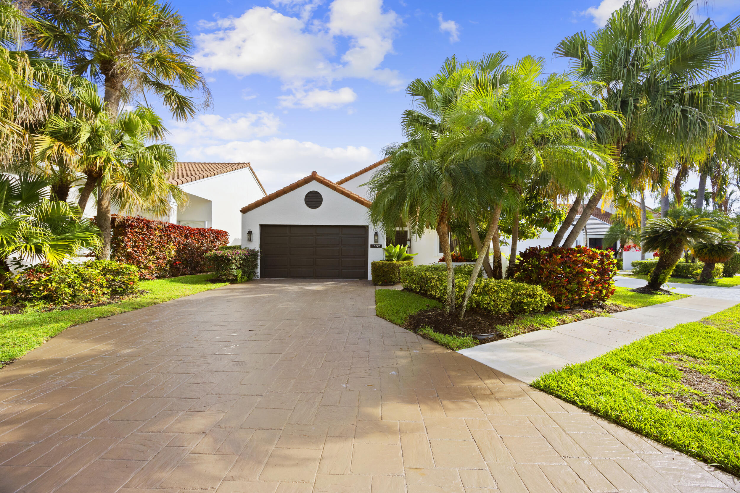 17192 Newport Club Drive Boca Raton, FL 33496 - Photo 2 of 72 a front view of a house with a yard and a garage