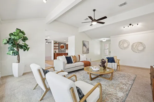 a living room with furniture a chandelier and a potted plant