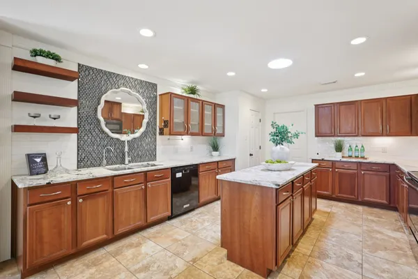 a kitchen with stainless steel appliances granite countertop sink stove top oven and cabinets