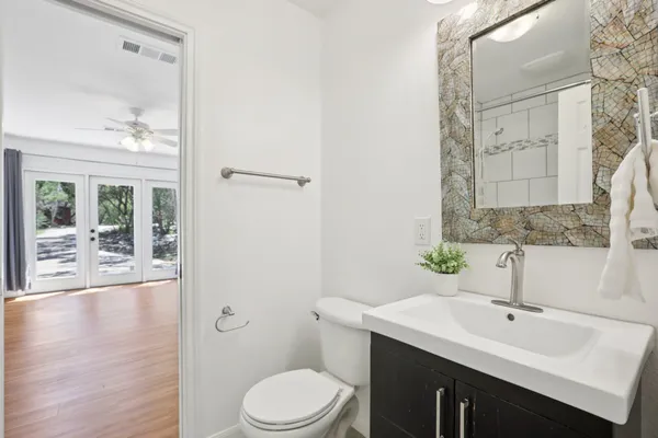 a bathroom with a sink a toilet and shower