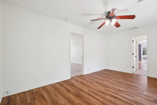 a view of empty room with wooden floor