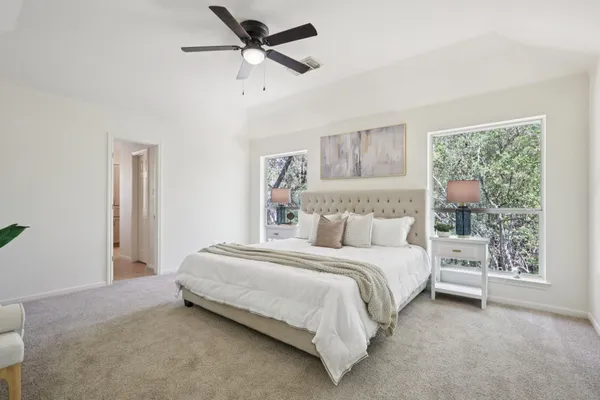 a bedroom with a bed painting on the wall and a window