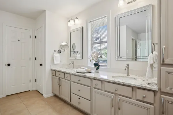 a bathroom with double sink and a mirror