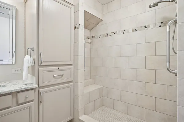 a bathroom with a granite countertop shower a mirror and a sink