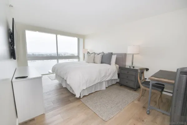 a bedroom with a bed and a large window