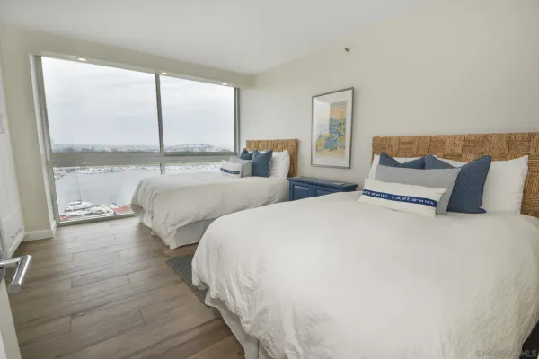 a bedroom with two beds and a large window