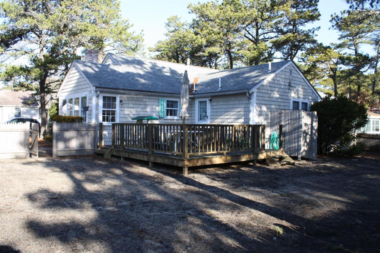 30 Longell Road Dennis Port, MA 02639 - Photo 4 of 19 a view of a house with wooden fence next to a road