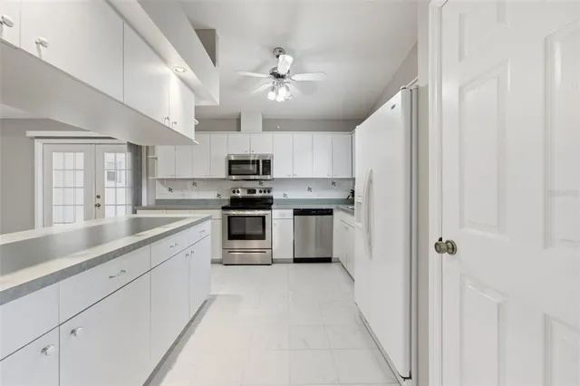 a kitchen with stainless steel appliances a refrigerator sink and microwave