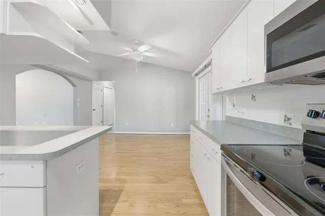a view of a livingroom with wooden floor and a ceiling fan