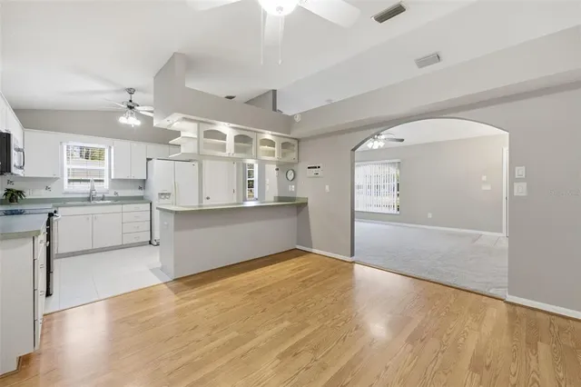 an empty room with windows and fan