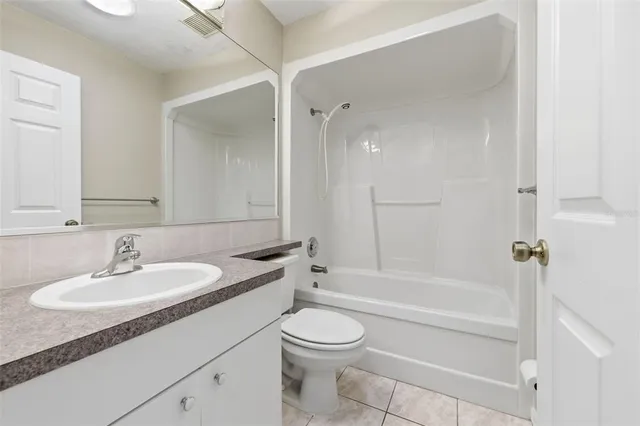 a view of a livingroom with a ceiling fan & windows