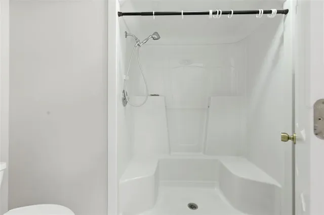 an empty room with a ceiling fan and window