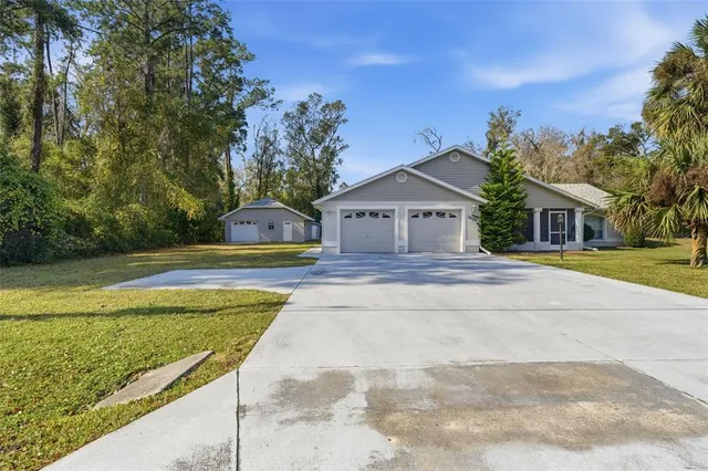 a front view of house with yard and trees in the background