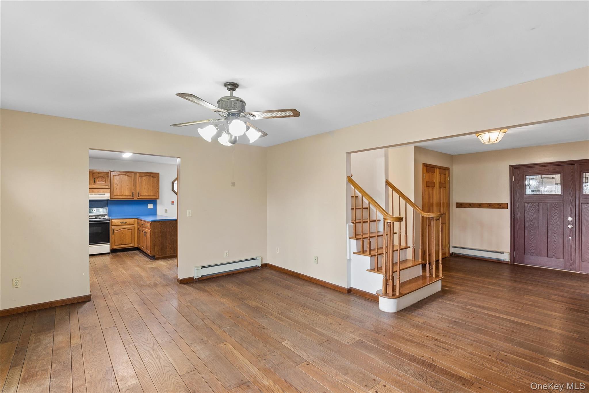 49 Overhill Road Wading River, NY 11792 - Photo 6 of 27 an empty room with wooden floor staircase and windows