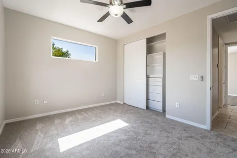 an empty room with closet and ceiling fan