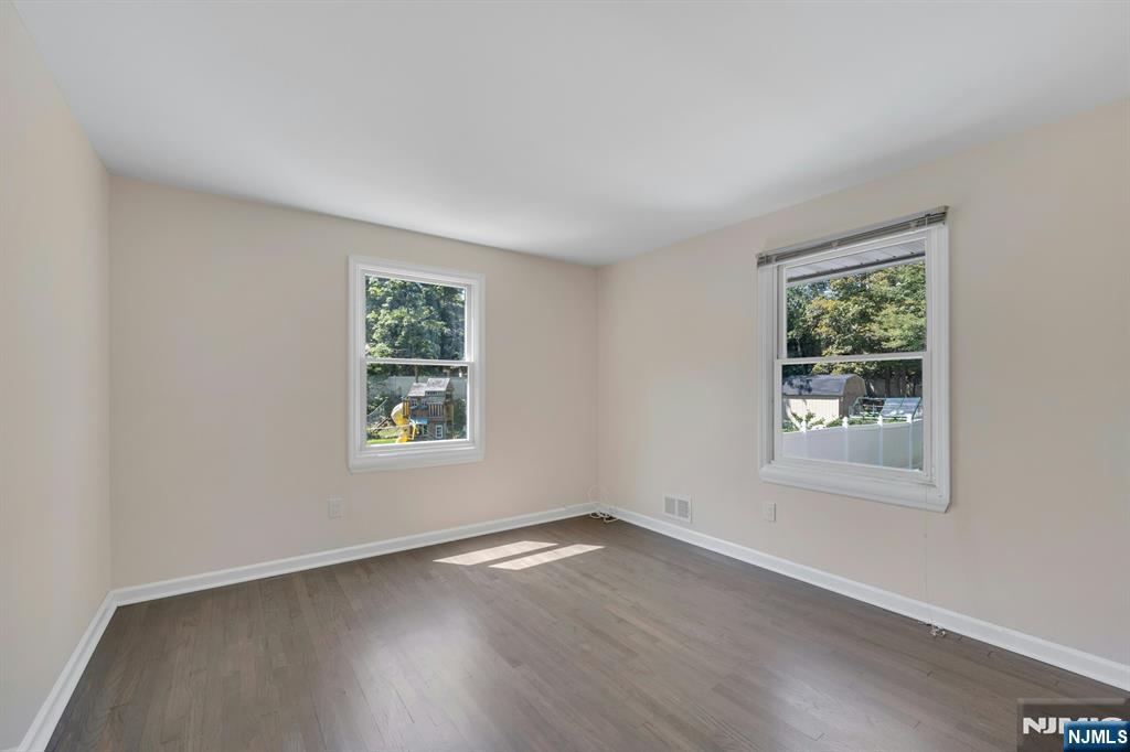 82 Little Falls Road Cedar Grove, NJ 07009 - Photo 16 of 36 a view of an empty room with wooden floor and window