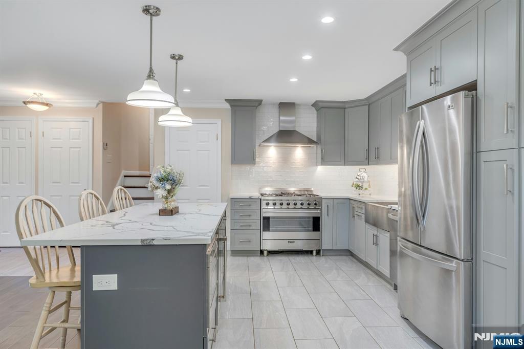 82 Little Falls Road Cedar Grove, NJ 07009 - Photo 4 of 36 a kitchen with kitchen island granite countertop a sink a center island and cabinets