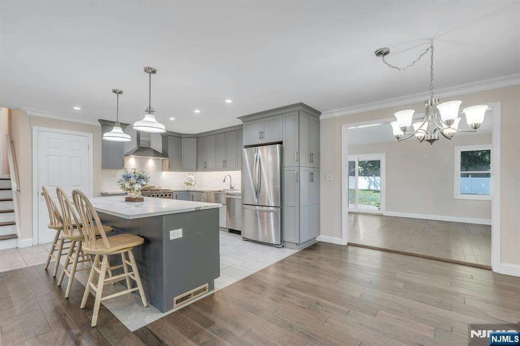 82 Little Falls Road Cedar Grove, NJ 07009 - Photo 5 of 36 a kitchen with kitchen island a dining table chairs stainless steel appliances and cabinets