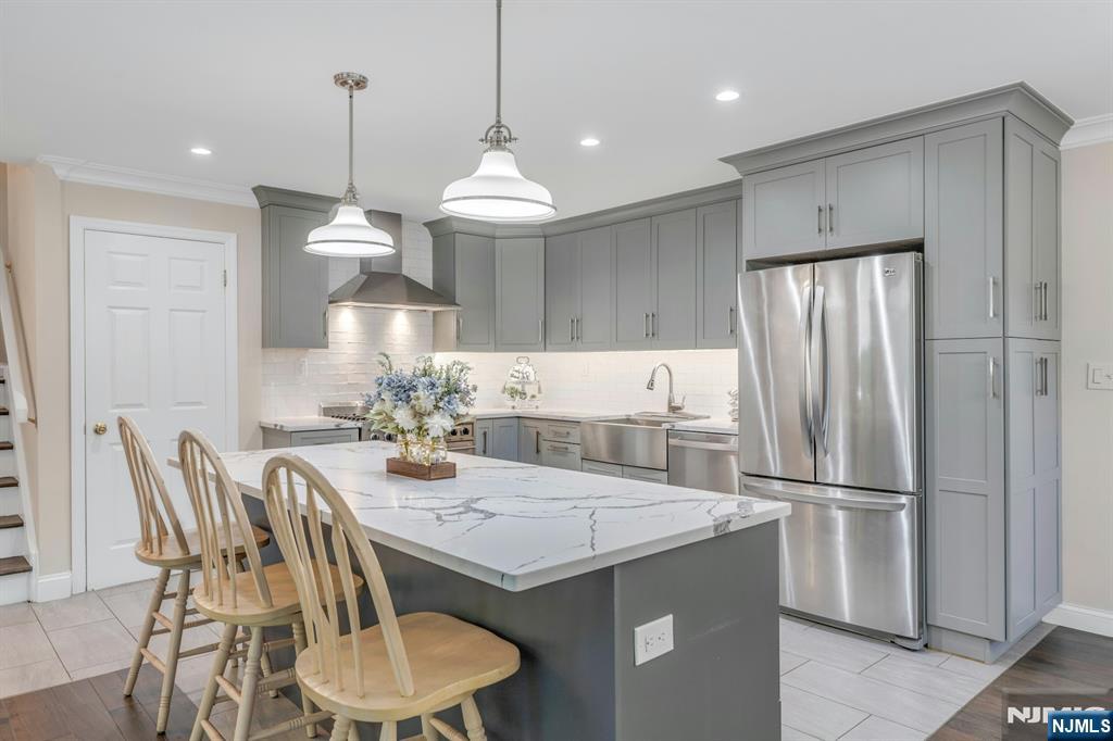 82 Little Falls Road Cedar Grove, NJ 07009 - Photo 6 of 36 a kitchen with stainless steel appliances granite countertop a kitchen island a table and chairs