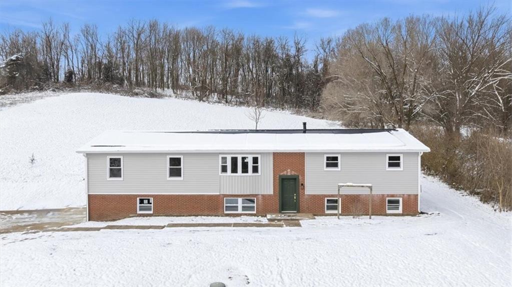 a view of a house with a yard covered in snow