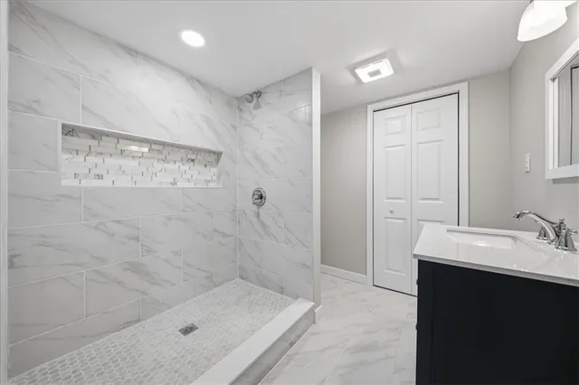 a bathroom with a sink shower and a mirror