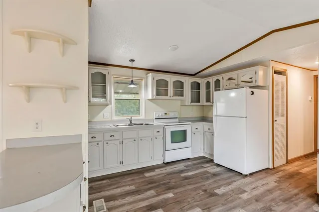 a kitchen with granite countertop white cabinets and white appliances