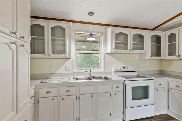 a kitchen with stainless steel appliances granite countertop a sink and a stove next to a window